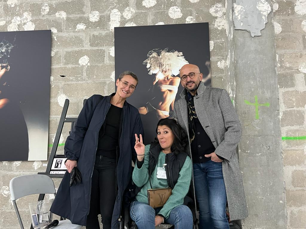 Samantha Groh, Rahim Rezzouk et Sanaa Anbar posent devant des photographies accrochées sur un immeuble en chantier